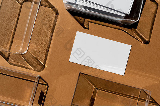 空白名片放在透明的盒子上，直射光线形成几何阴影