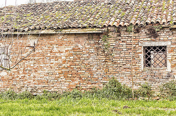 窗口菱形形状的生锈的炉篦砖墙毁了房子cotignola意大利