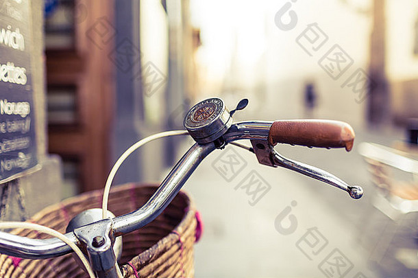 模糊背景下的城市自行车把手和篮子，城市街道上的自行车自行车，城市中的通勤复古概念