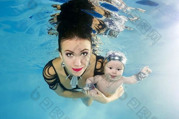 妈妈带着一个小儿子微笑着潜入游泳池
