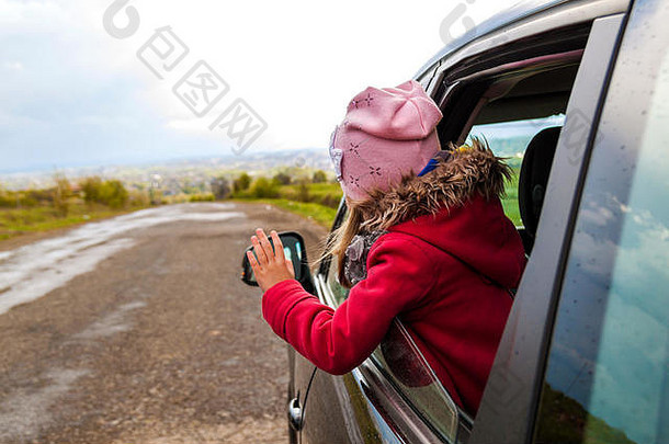 车里漂亮的小女孩从车窗往外看。旅游概念。
