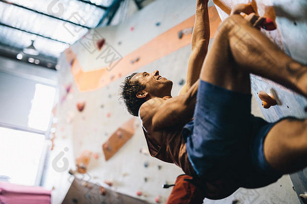 男人。抱石室内攀爬中心热情的登山者练习岩石攀爬室内攀爬健身房