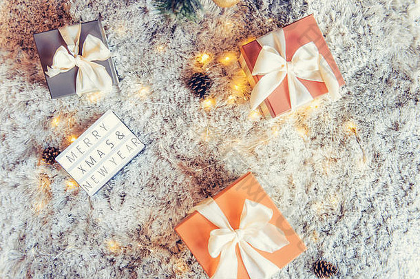 顶视图：灯箱组成，圣诞快乐，<strong>新年</strong>祝福，彩色节日包装，圣诞树下系有蝴蝶结的礼物