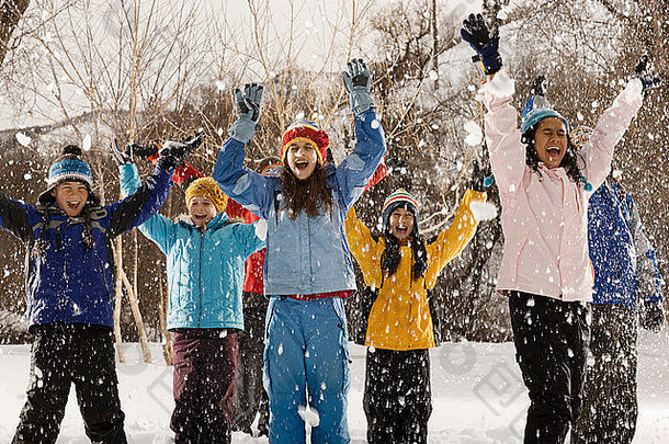 一群年轻人，户外的男孩和女孩，在下雪的天气下笑着