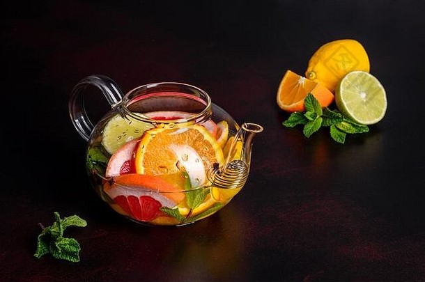 在一个漂亮的玻璃茶壶里放着柠檬、薄荷、橙子、酸橙和葡萄柚的热水果茶