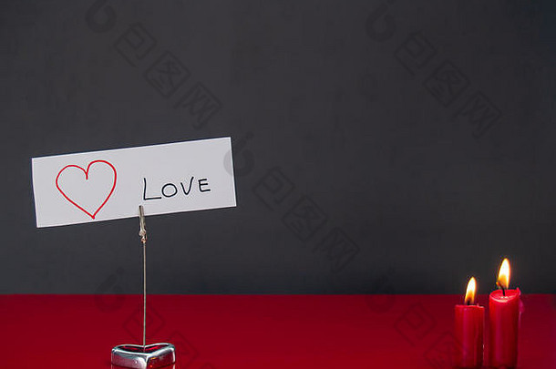 爱的概念点燃了红色蜡烛和心形的烛台，上面写着“我爱你”