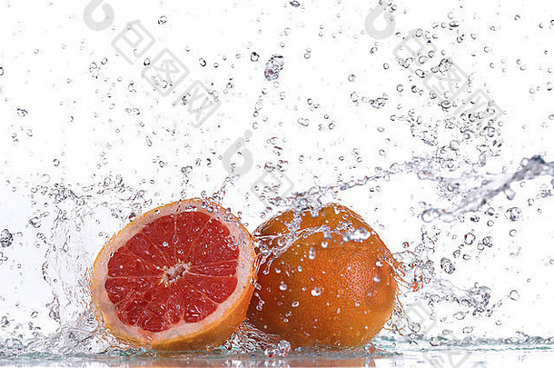葡萄柚与水的飞溅隔离在白色