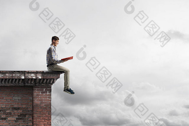 屋顶边上的人在看书，背景是云景