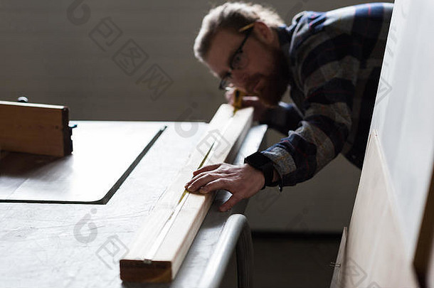 测量木材的男木匠