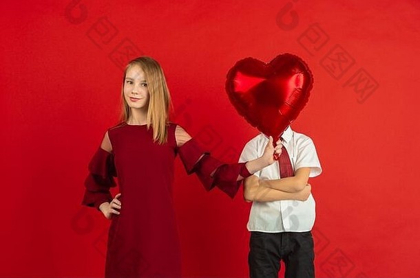 心形气球。情人节庆祝活动，快乐、可爱的白人孩子被隔离在红色工作室的背景下。人类情感的概念，面部表情，爱情，关系，浪漫的节日。