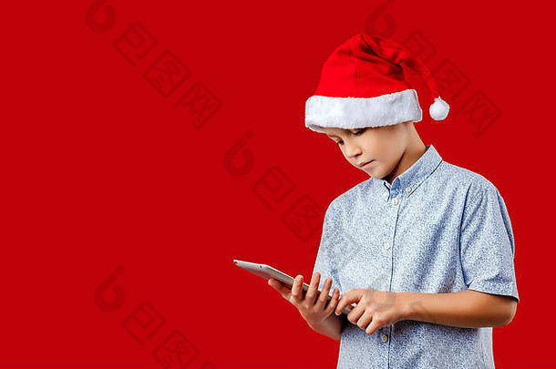 年轻的男孩圣诞老人他平板电脑垫