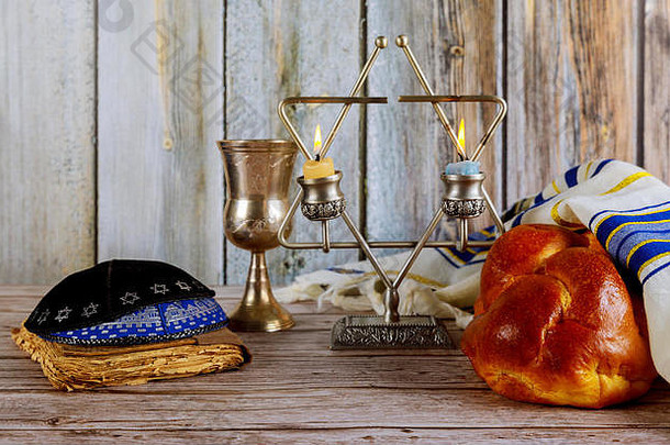 安息日犹太节日芝麻沙拉面包和烛台摆在桌上