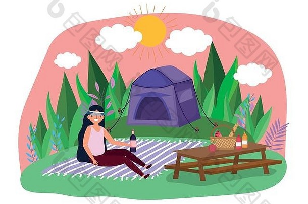 带着酒瓶毯子和帐篷在公园野餐的年轻女子