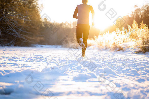 图片来源于穿着运动服、戴着红帽子在冬季跑步的男子背部