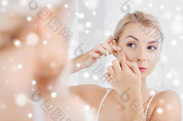 在浴室镜子前挤粉刺的女人