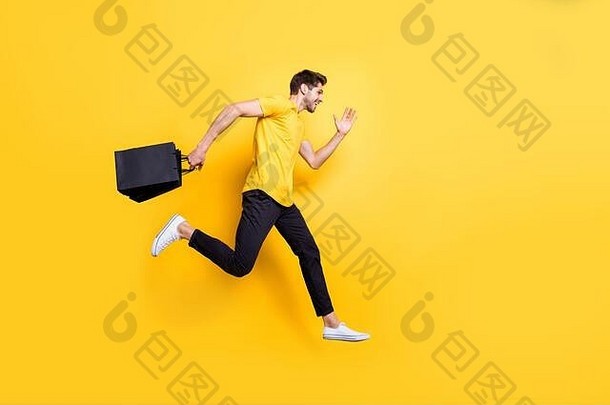 帅哥跳跃高抱包裹快速抢购购物服休闲t恤裤子独立黄色背景全尺寸照片