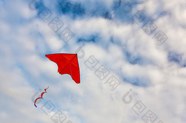 红色的风筝飞行蓝色的天空白色云