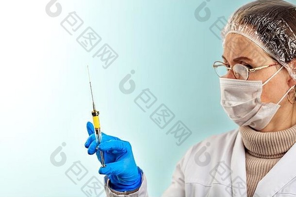 一位戴着乳胶医用手套的医生用一个小注射器检查疫苗。病毒防护的概念。浅色turquoi上的医学主题