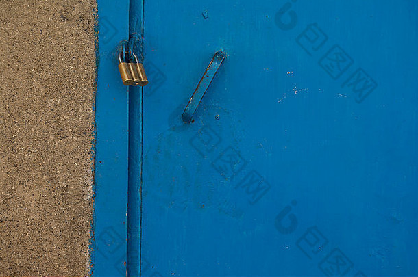 金色挂锁系在建筑物的蓝色门上