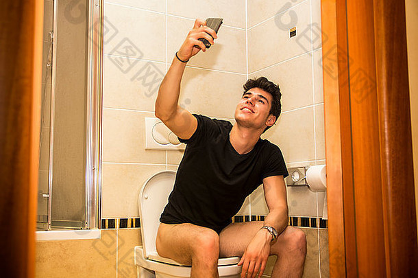 微笑的年轻人在浴室大便时用手机自拍