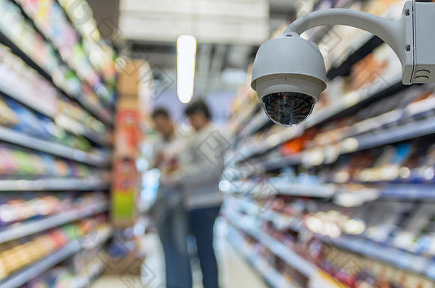 安全摄像头监控百货商店背景中抽象模糊的店铺照片，基于安全理念的商业购物