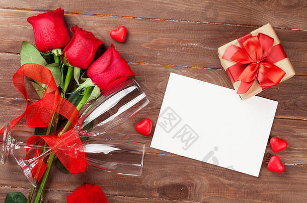 情人节贺卡，礼品盒和红<strong>玫瑰</strong>放在木桌上。具有空间的俯视图