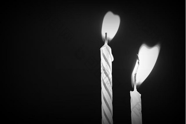 深色背景特写下的生日蜡烛。非黑即白的