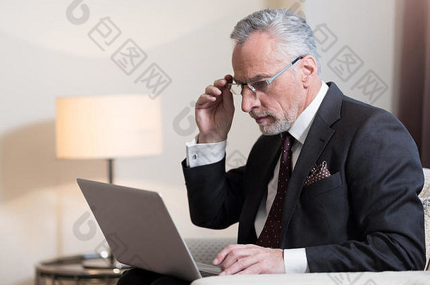 专注的商人在酒店使用笔记本电脑