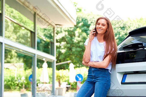 拍摄休闲年轻的女人会说话的移动电话站街车