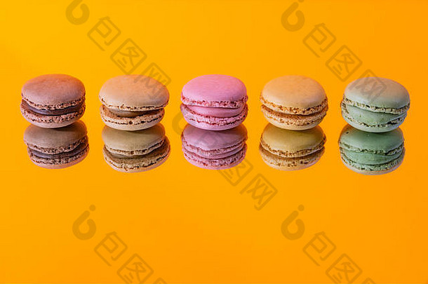 美味的五颜六色杏仁饼，独立于一面镜子和一个五颜六色的背景和反映当代装饰