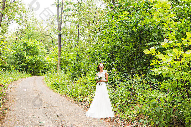 新娘手持一束白色马蹄莲和蓝色花朵