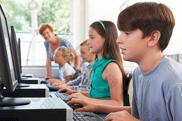 一组小学生与老师一起上计算机课