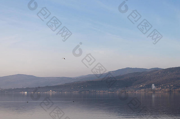 特拉西门诺湖（意大利翁布里亚）的美景，群山和蓝天映在水面上