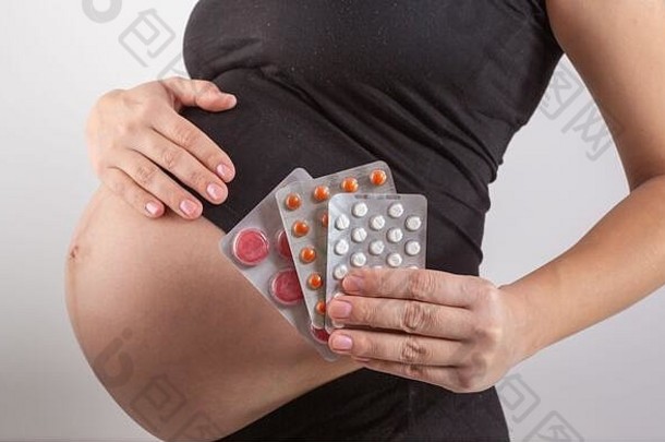 怀孕、人与保健概念-孕妇特写。孕妇维生素和矿物质。怀孕期间服药