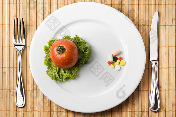 盘子里的药物说明了药物和健康饮食之间的选择