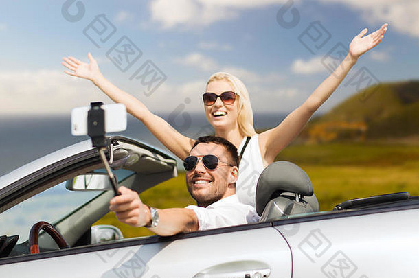 幸福夫妻在车上用智能手机自拍
