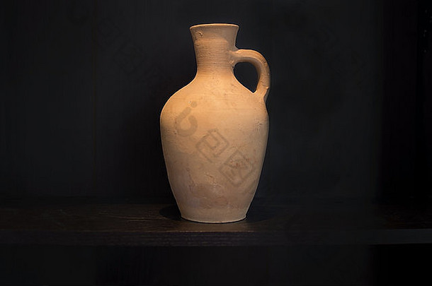 赤陶花瓶陶器家居用品，手工制作，置于深色搁板上，黑色明暗对比风格。