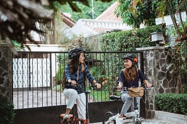 两个小女孩准备骑折叠自行车上学