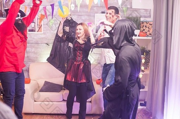 吸血鬼女人在和她的朋友们庆祝万圣节的时候唱歌。