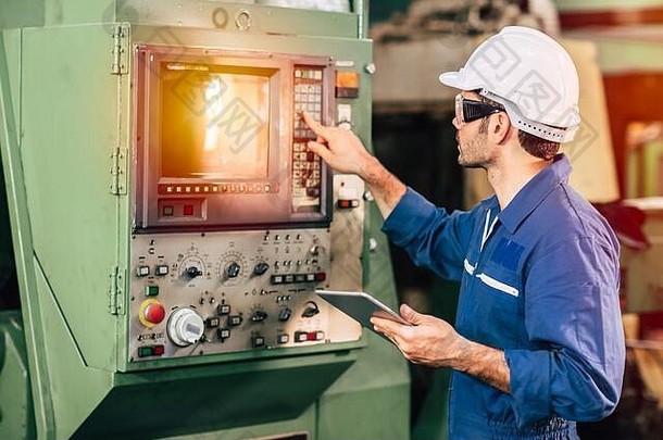 工厂工人操作机器，高技能工人穿着安全服在工业中工作。