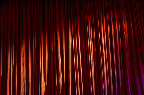 红色的窗帘和舞台上的聚光灯。