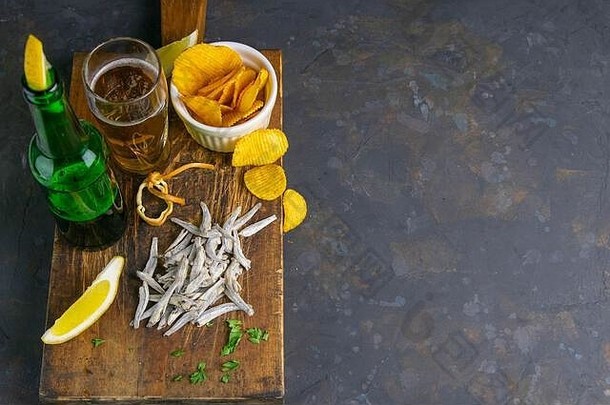 干咸凤尾鱼啤酒柠檬土豆芯片黑暗木董事会零食鱼啤酒前的观点清晰的空间