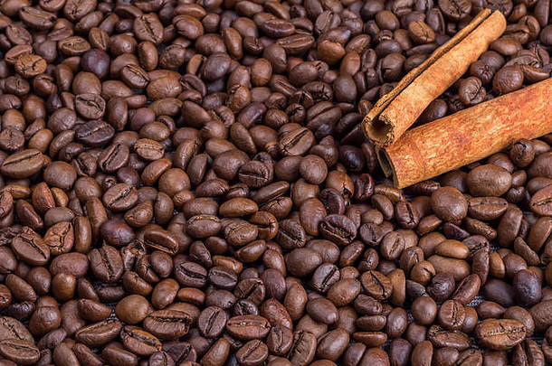 咖啡豆上的肉桂。很多咖啡豆背景。