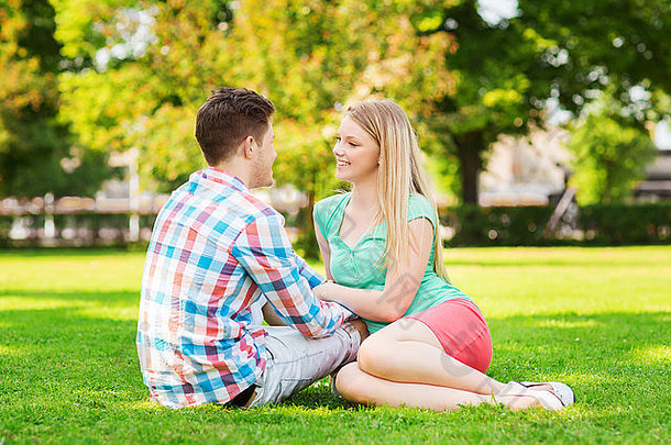 微笑夫妇坐着草公园