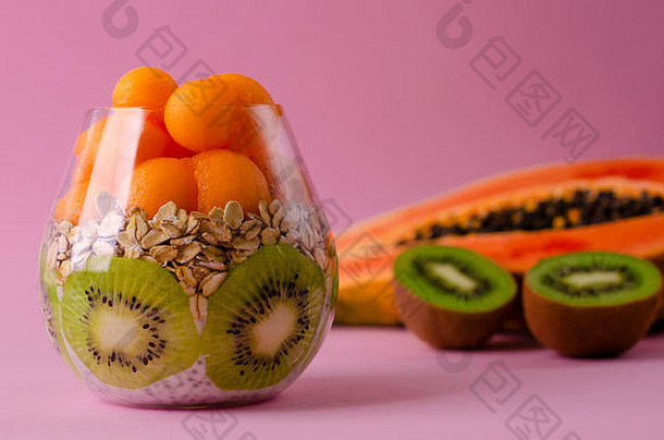 传讲布丁猕猴桃水果oatmeals木瓜球玻璃紫色的背景排毒饮食超级食物早餐概念复制空间
