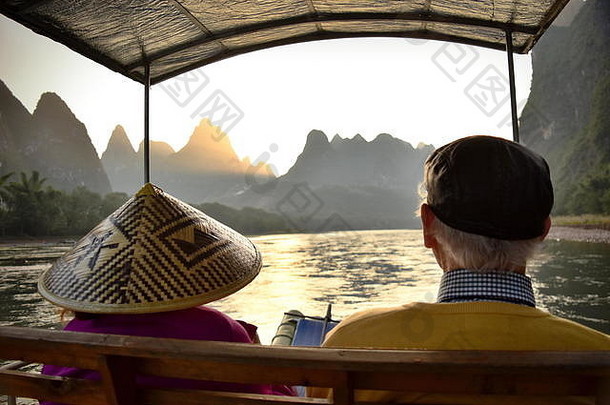 活跃的高级旅游夫妇享受美丽的日落河盆地山广西中国
