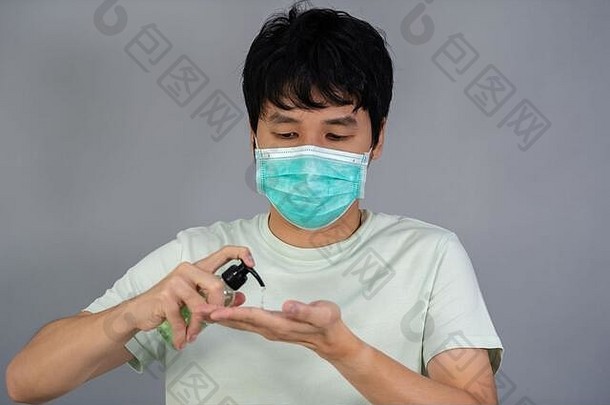男子在医用口罩（外科口罩）上使用酒精凝胶，冠状病毒防护