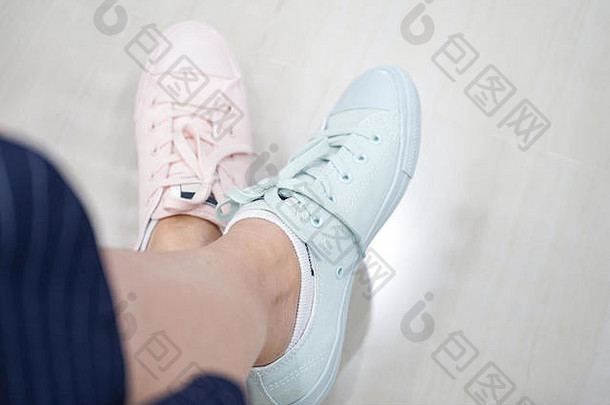 gal在运动和时尚鞋店尝试粉彩运动鞋粉彩色调和颜色。