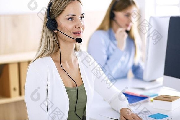 呼叫中心接线员工作时的肖像。一群人戴着耳机随时准备帮助客户。经营理念