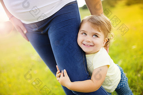 肖像快乐女儿持有怀孕了母亲´s手公园